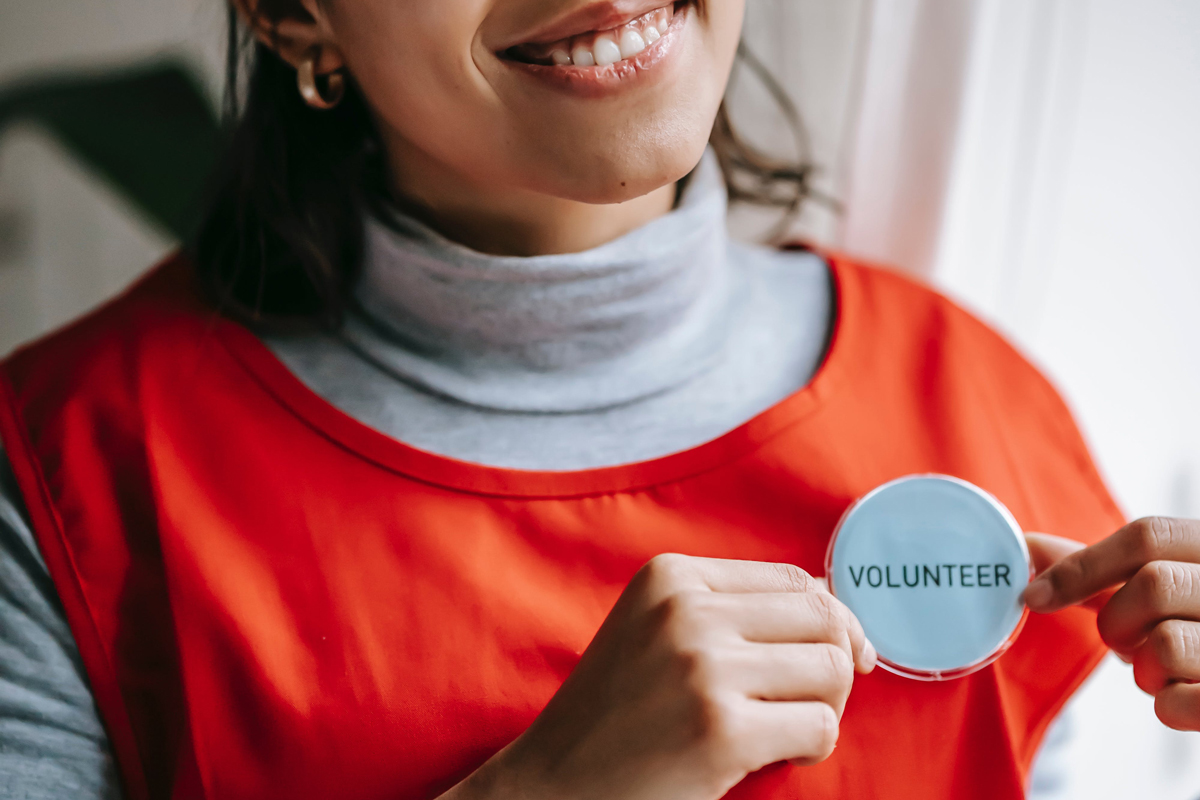 close up of volunteer badge on woman’s shirt